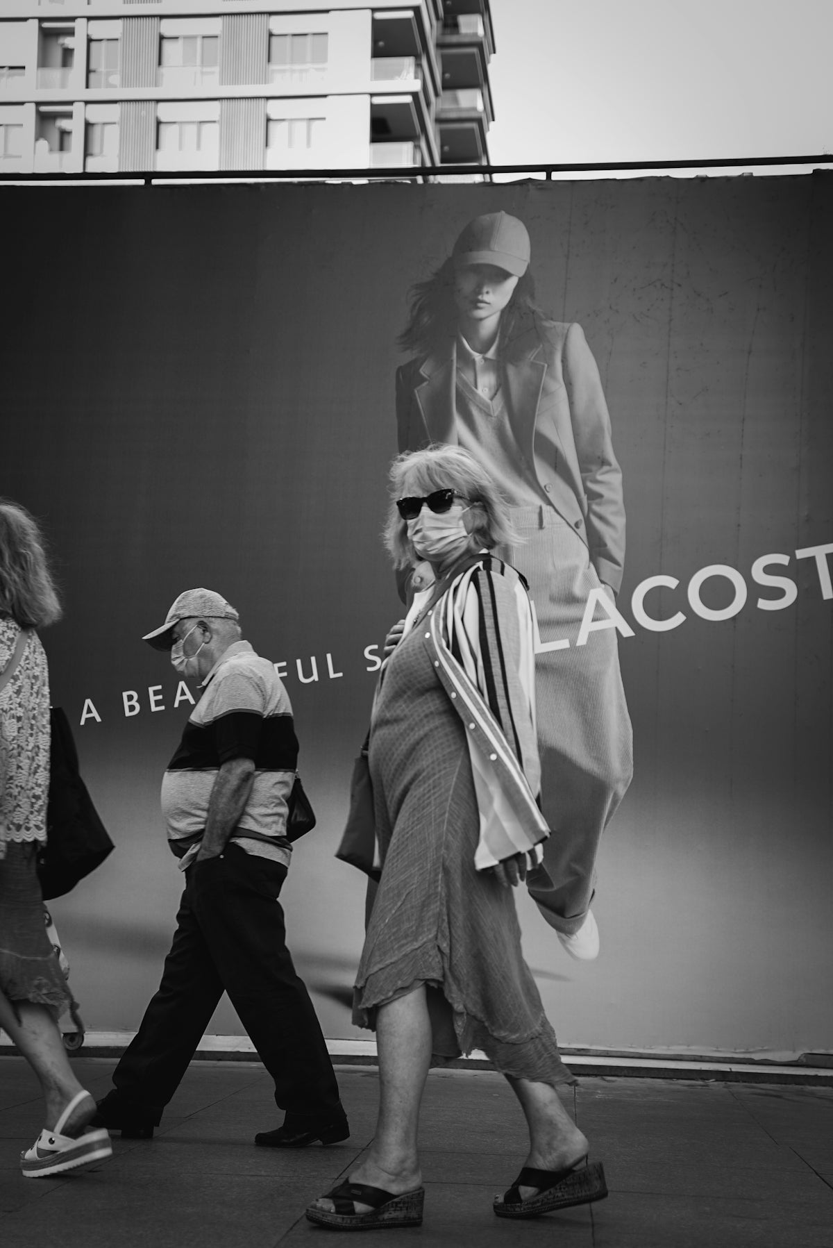 grayscale photo of man and woman standing in front of the wall