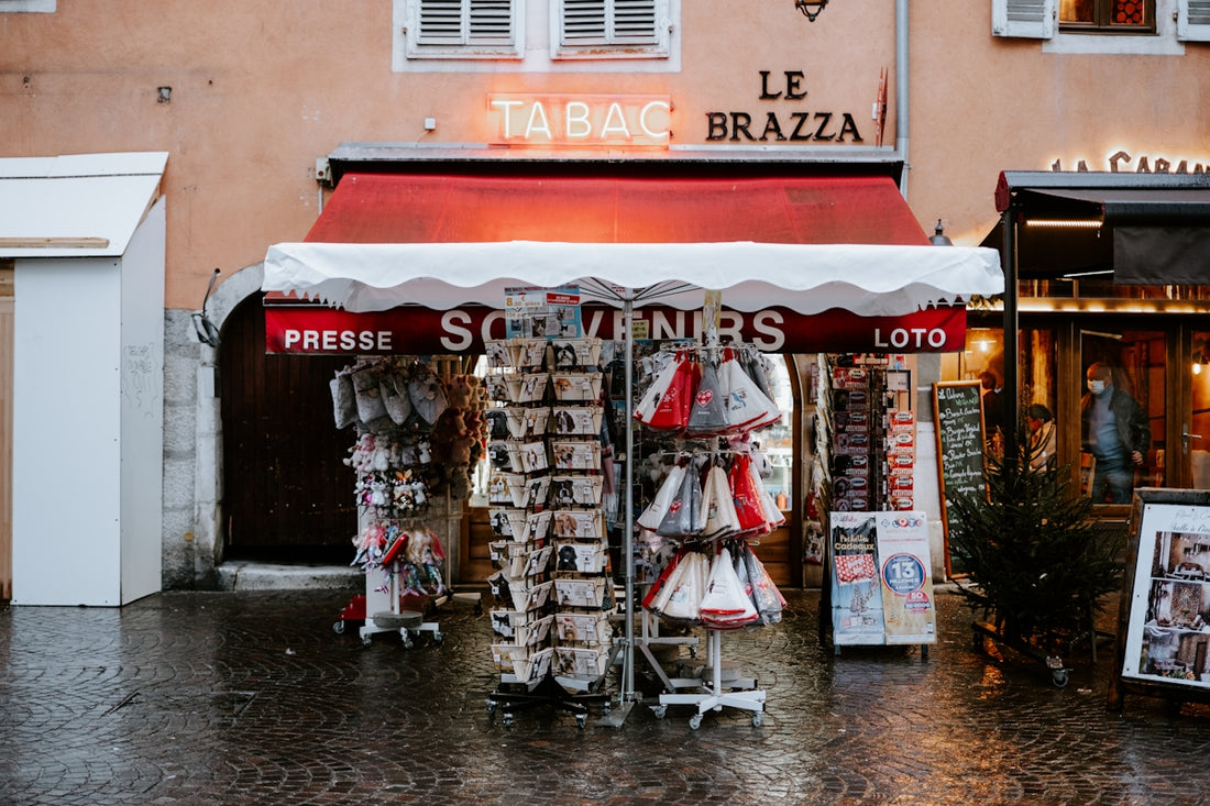 a store with a red and white awning on a rainy day