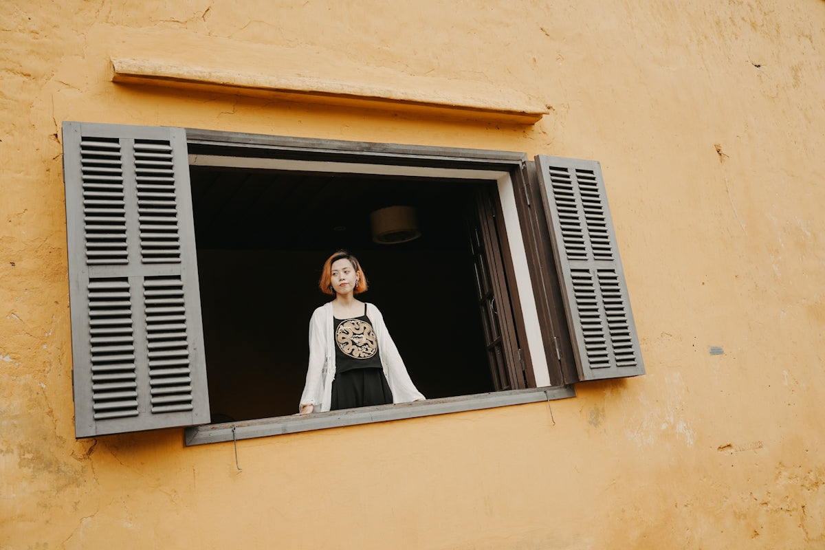 a woman standing in a window of a building
