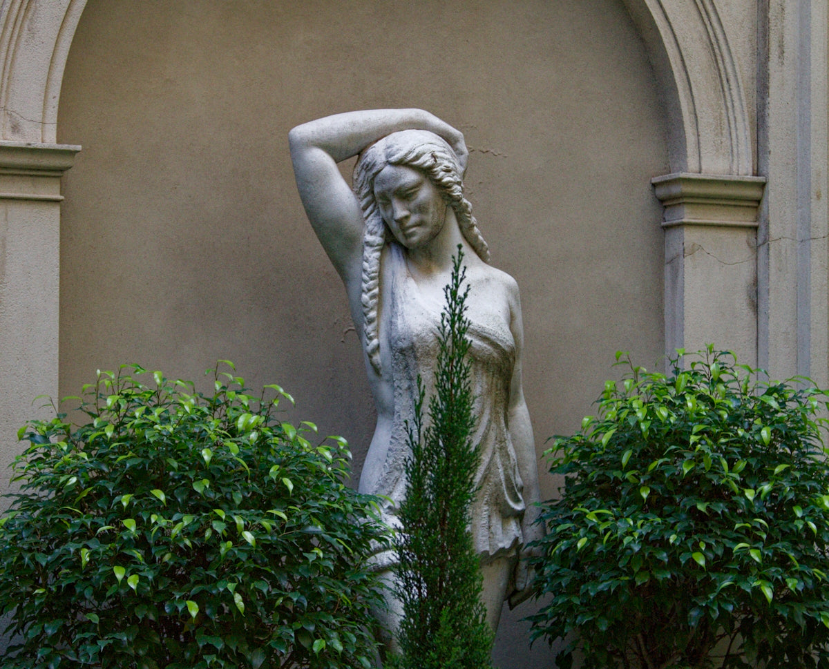 a statue of a woman holding her head in her hands