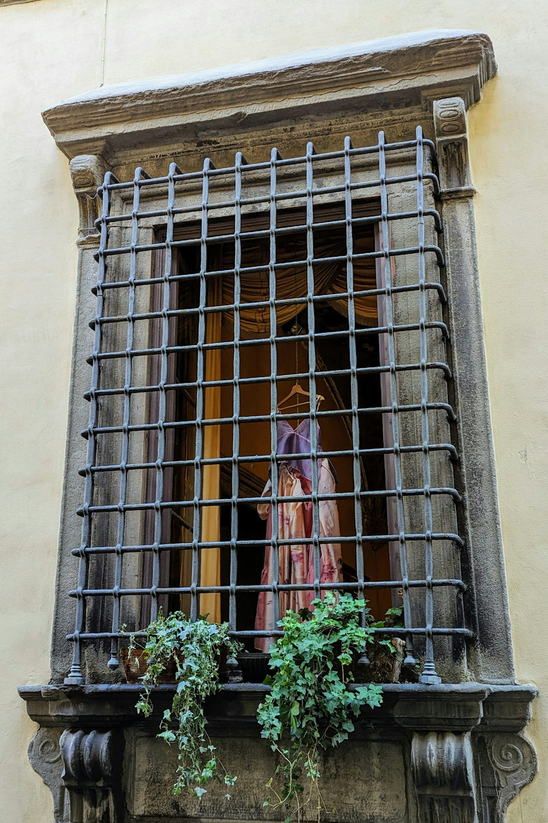 a window with bars on it and a statue in the window
