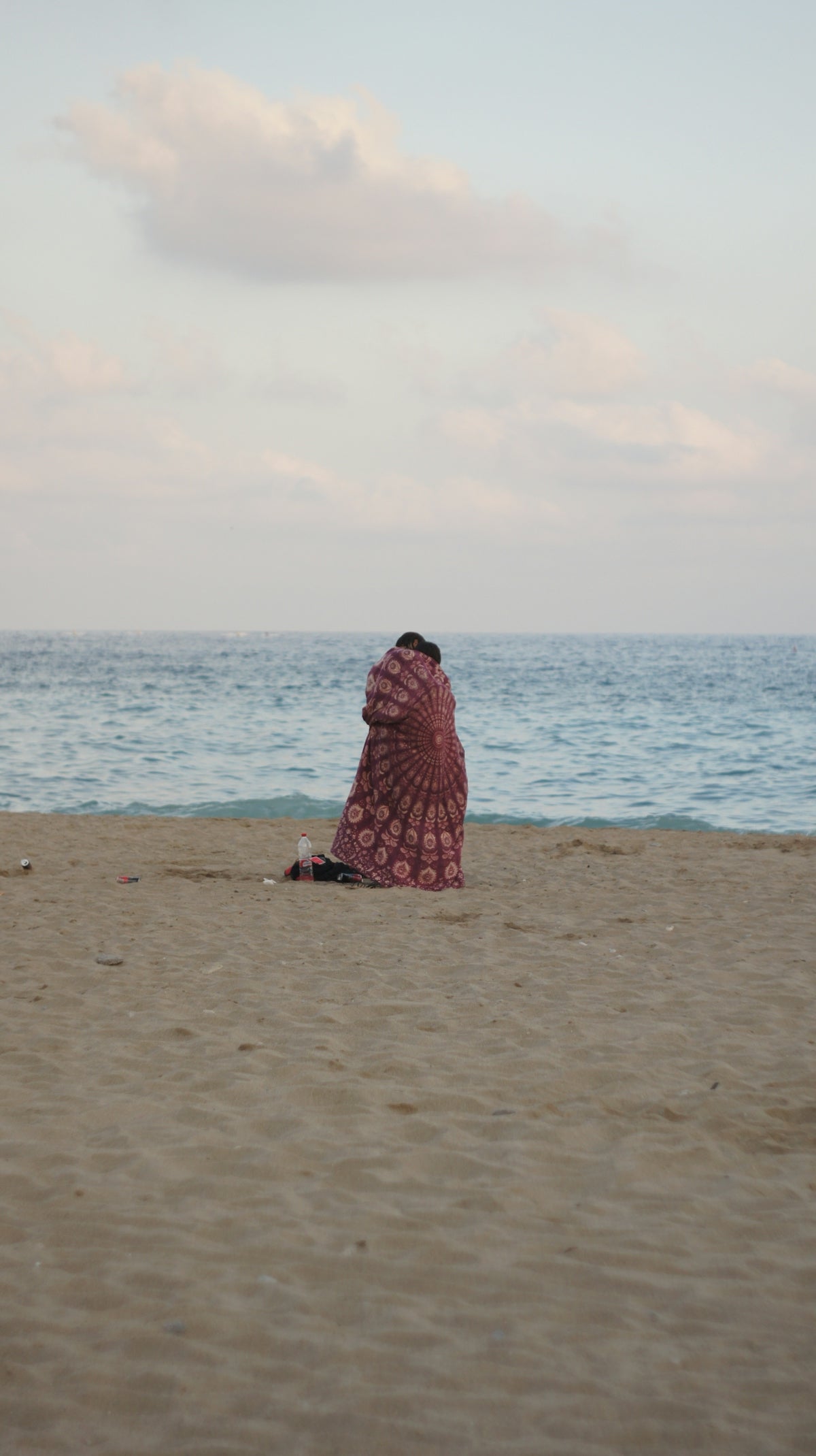 a woman sitting on a beach next to the ocean