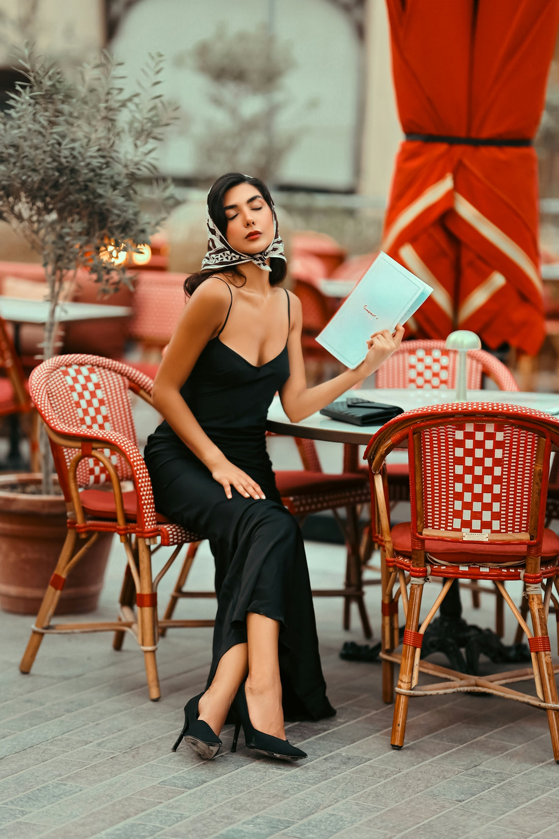 A woman in a black dress sitting at a table