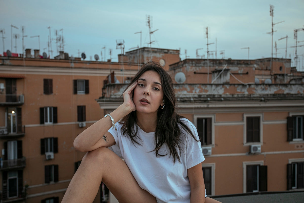 A woman sitting on a ledge in front of a building