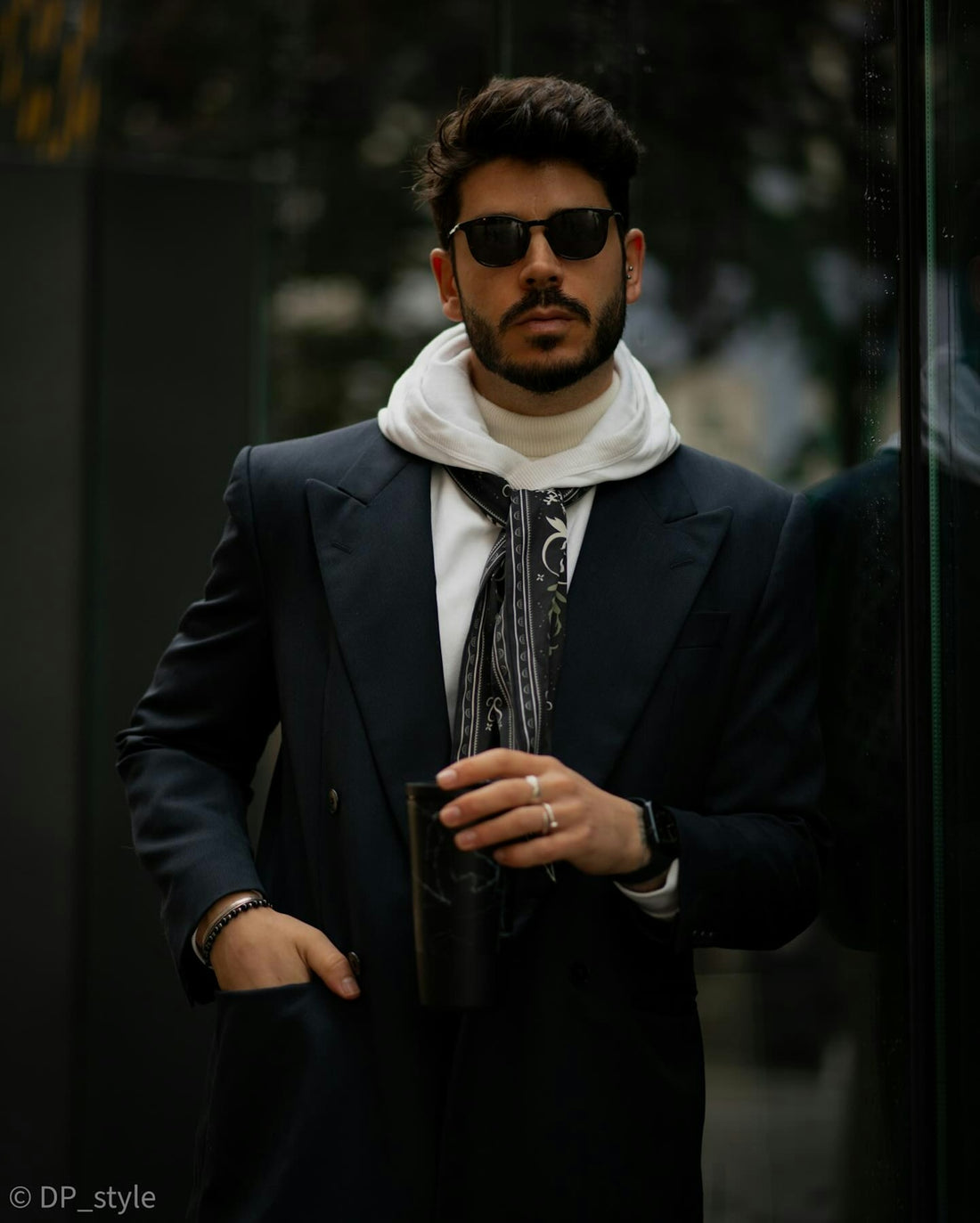 Stylish man in modern city attire posing.