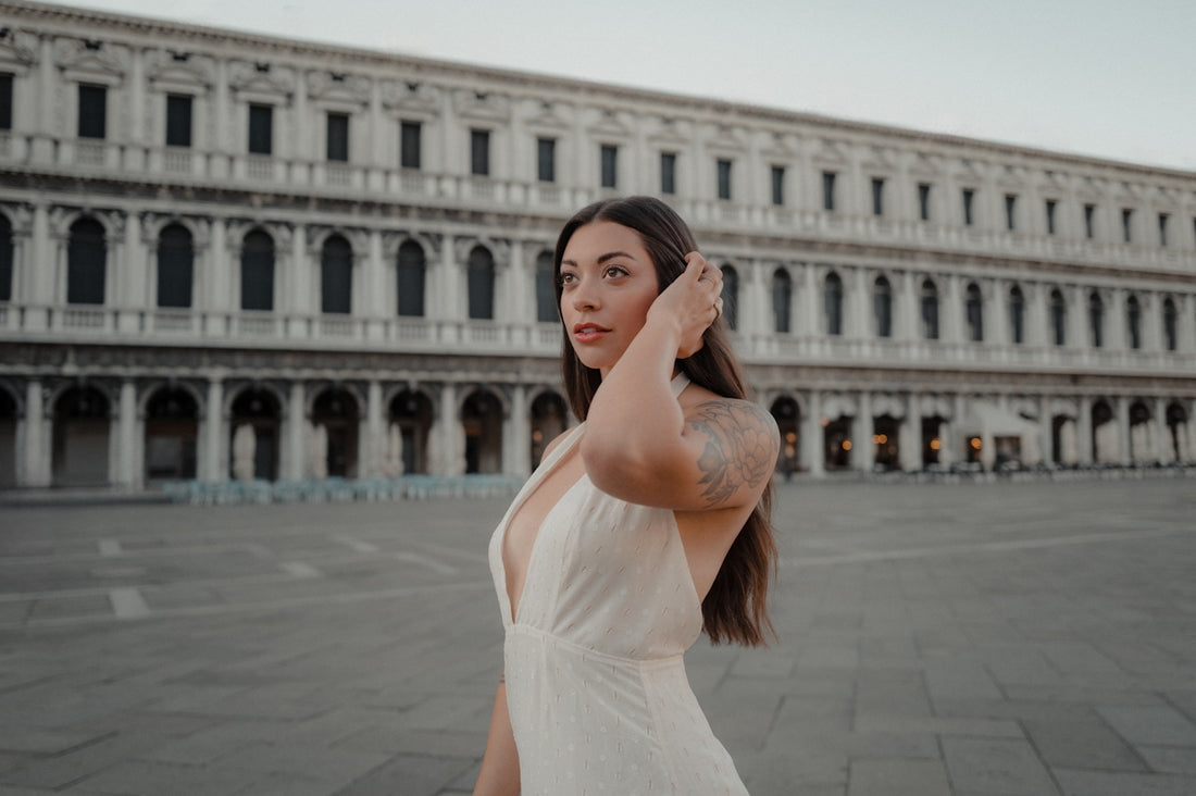 Young woman in a white dress in front of a building