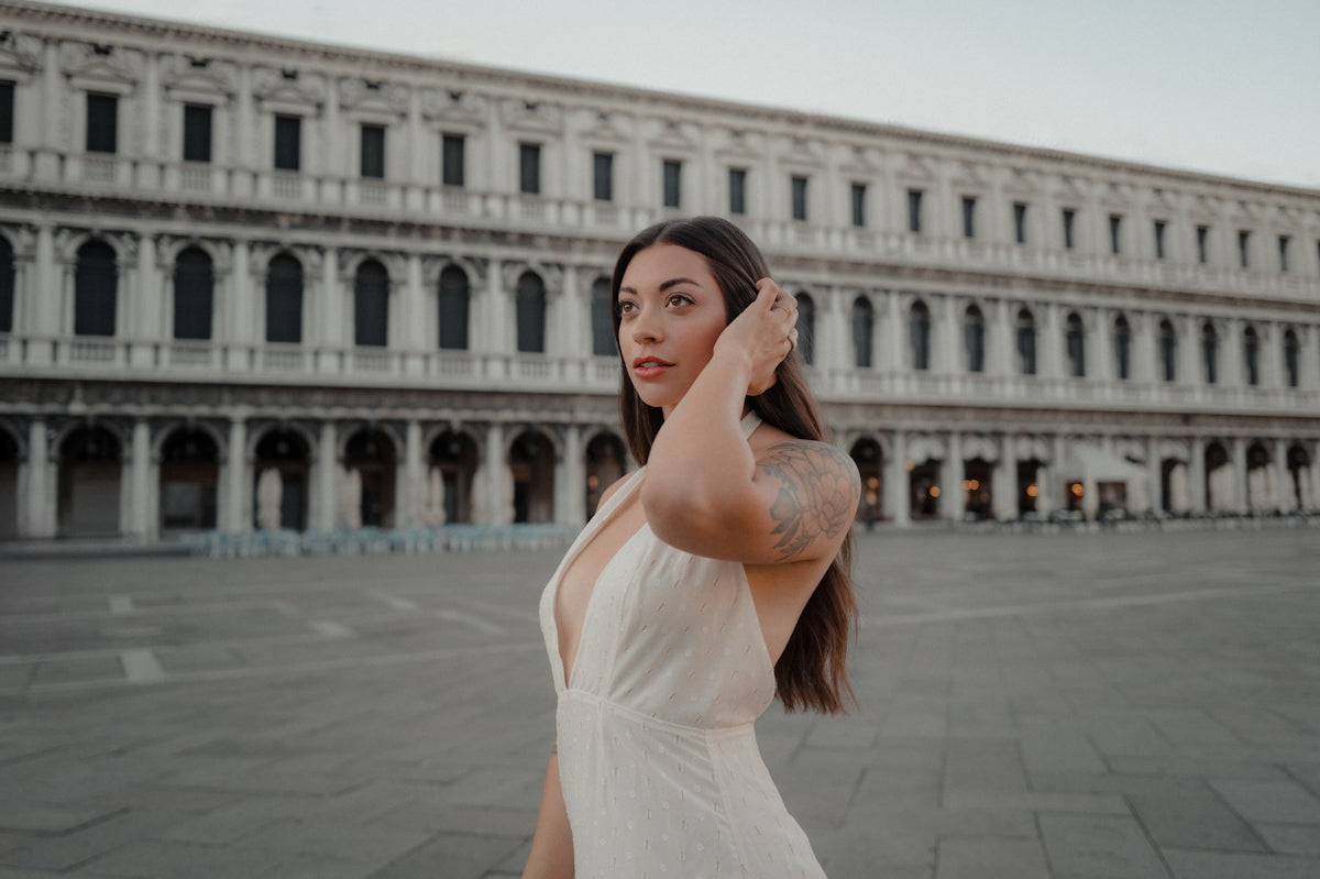 Young woman in a white dress in front of a building